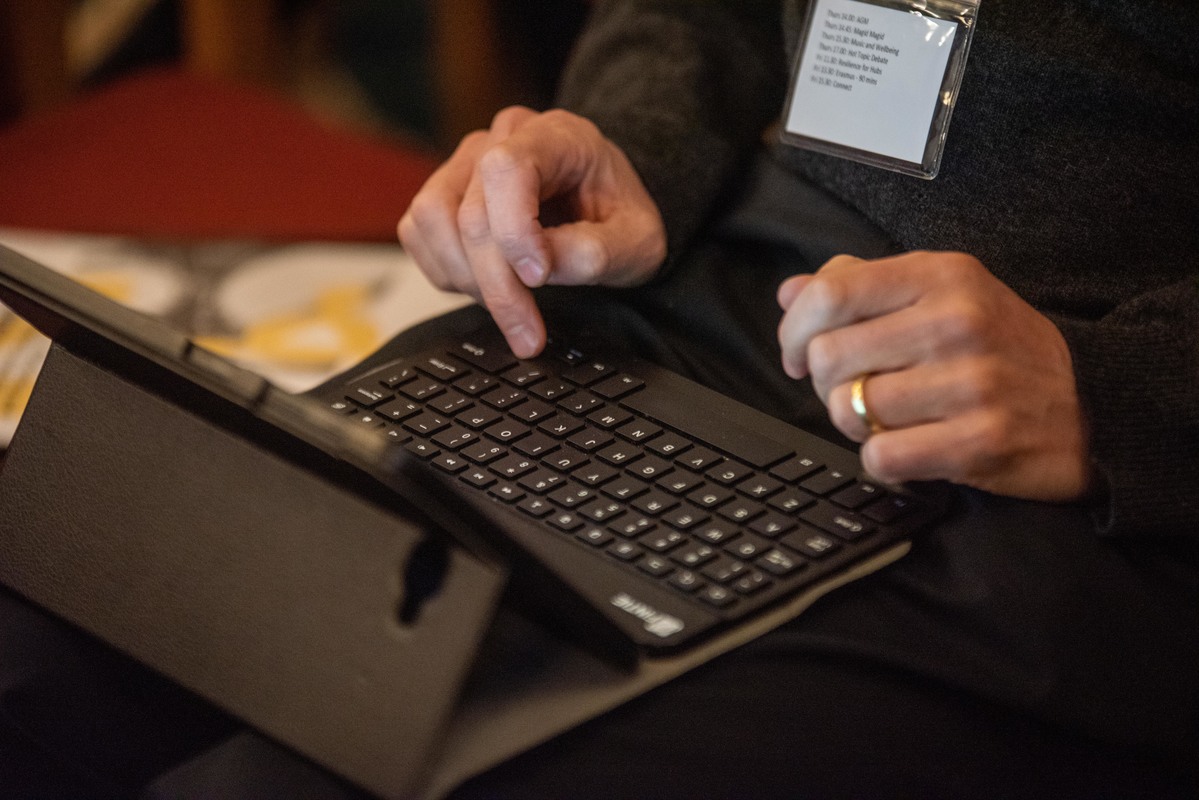 A black mini laptop with hands above the keyboard